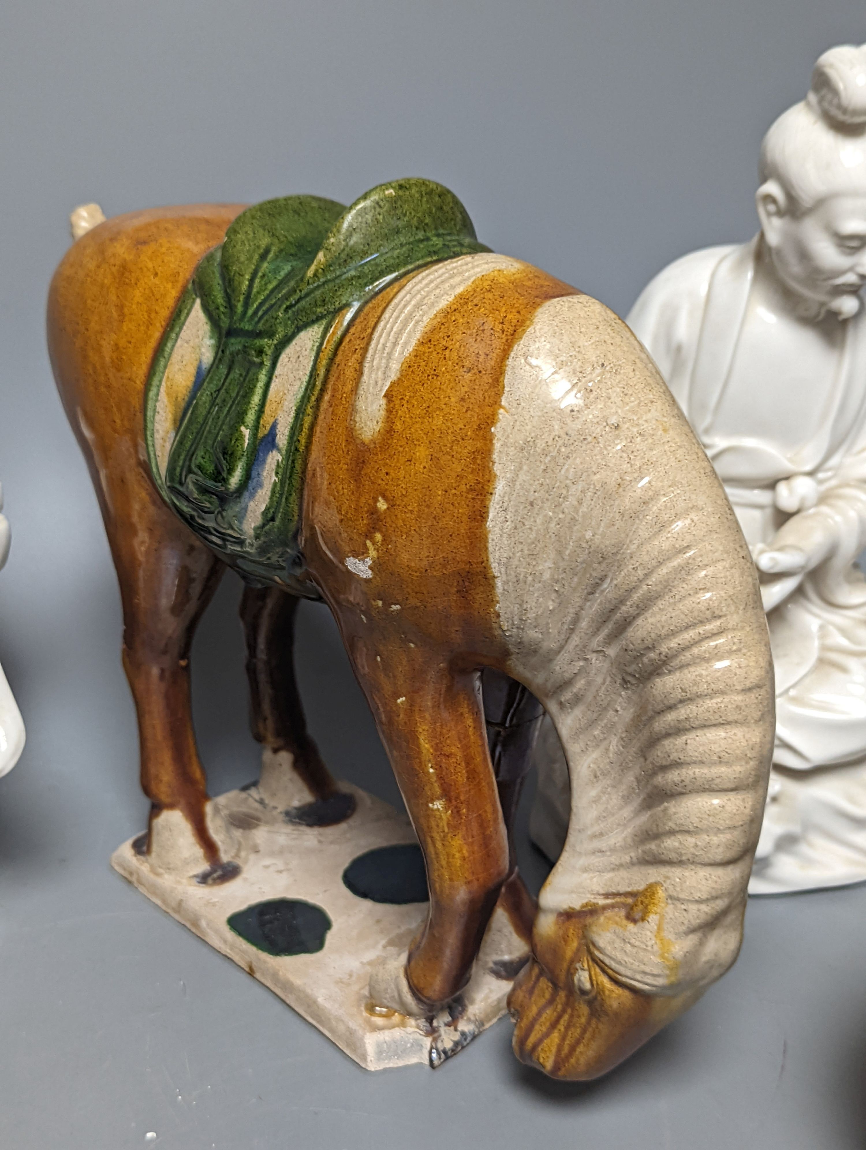 A Chinese Tang style sancai pottery horse, 21cm high, two Chinese blanc de Chine figures, 26cm high and two other items